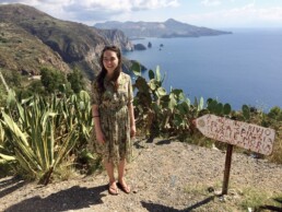 Viven Thiermeyer standing in front of an mountainous ocean landscape.